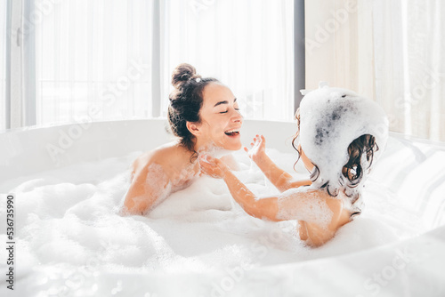 Mother and child having bubble bath.