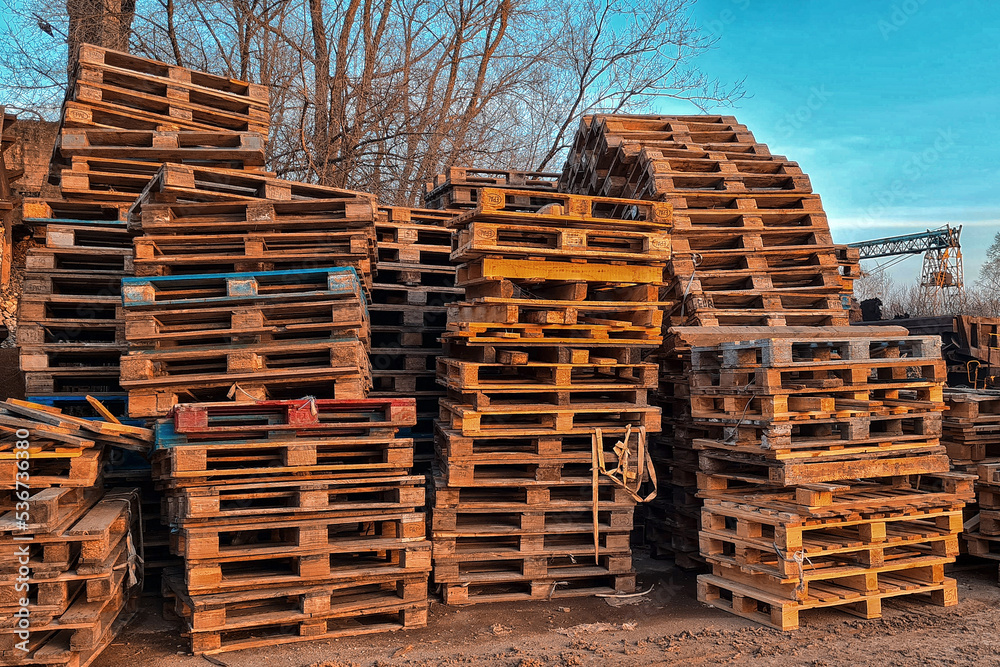 Many Old Used Wooden pallets is stack outdoors in warehouse of cargo delivery enterprise. Many Old Used Wooden pallets is stack outdoors in warehouse of cargo delivery enterprise.