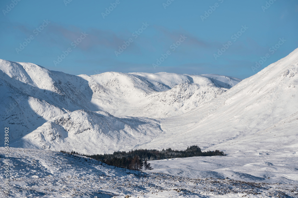 Obraz premium Beautiful Winter landscape image looking towards Scottish Highlands mountain range across Loch Ba on Rannoch Moor