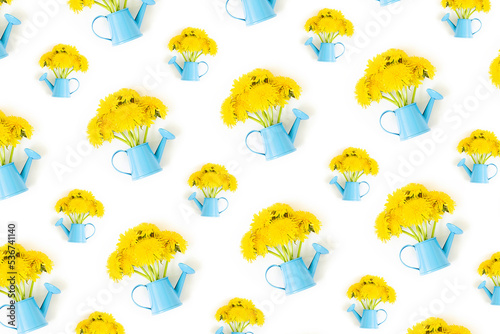 Bouquet of yellow dandelions flowers in blue watering can isolated on white background. Top view Creative Flat lay Minimal style