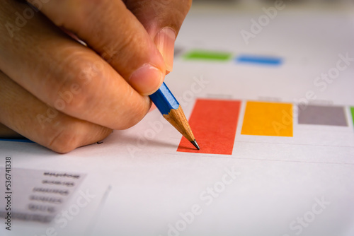Close up of a pencil with a hand pointing at bar chart on financial information sheet for business, finance, investment, tax concept.