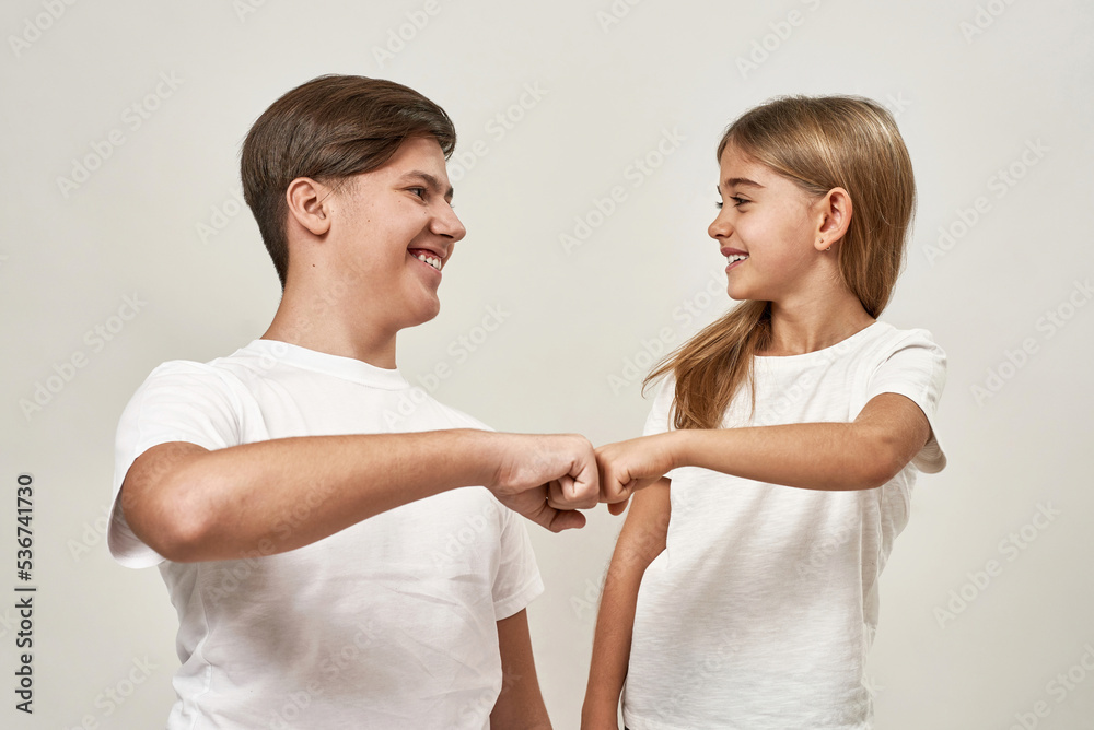 Teenage boy and little girl bumping fists Teenage boy and little girl bumping fists