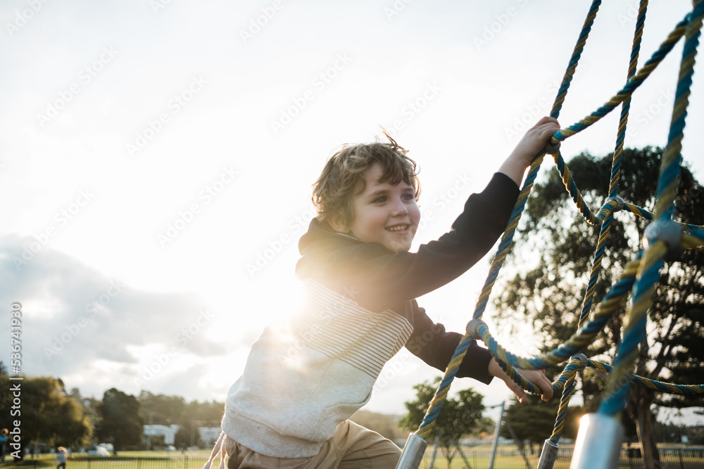 Kid playing at the park outdoors climbing Kid playing at the park outdoors climbing