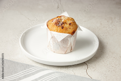 close up shot of a chocolate muffin on a white plate