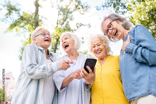 Group of seniors people bonding at the park - Beautiful old female friends using modern smartphone technology and social media app