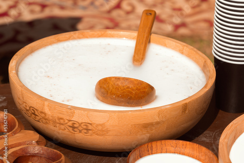 Traditional Asian wooden utensils with mare's milk koumiss or camel milk - shubat for sale in a street shop