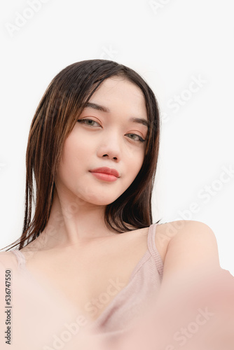 A smiling young woman taking a selfie using the front camera. Studio shot isolated on white background.