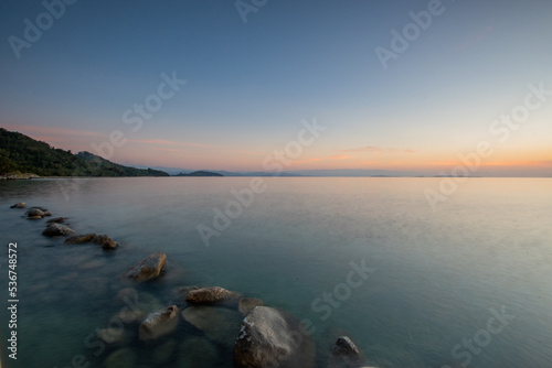 Sunset on sabang tende island, tolitoli, central sulawesi, indonesia with visible rock and coral using long exposure