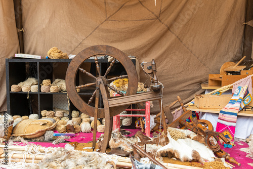 spinning wheel exposed between balls of wool