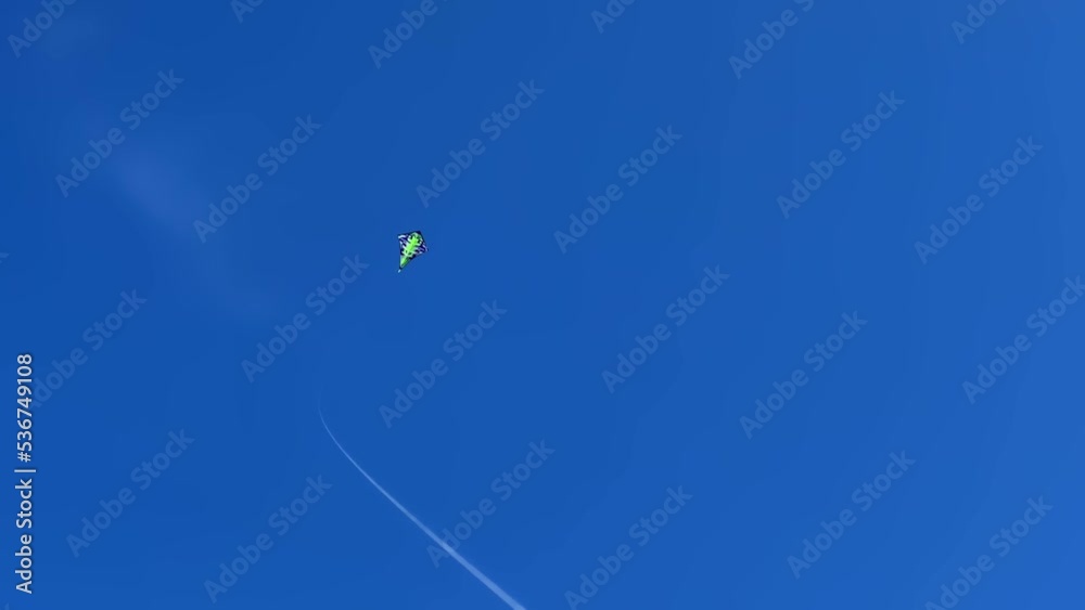 Green kite with long string flying in deep blue sky. Freedom concept Green kite with long string flying in deep blue sky. Freedom concept