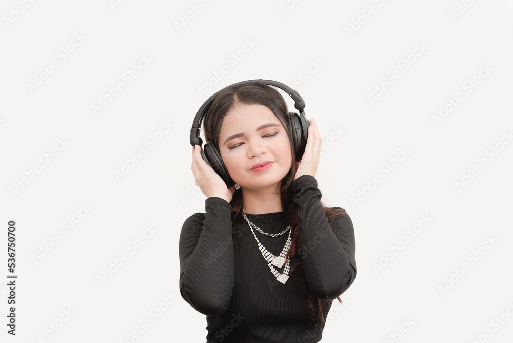 A studio portrait with white background of an Asian woman using a wireless headphones while listening to music. Feeling the emotions of the song. A studio portrait with white background of an Asian woman using a wireless headphones while listening to music. Feeling the emotions of the song.