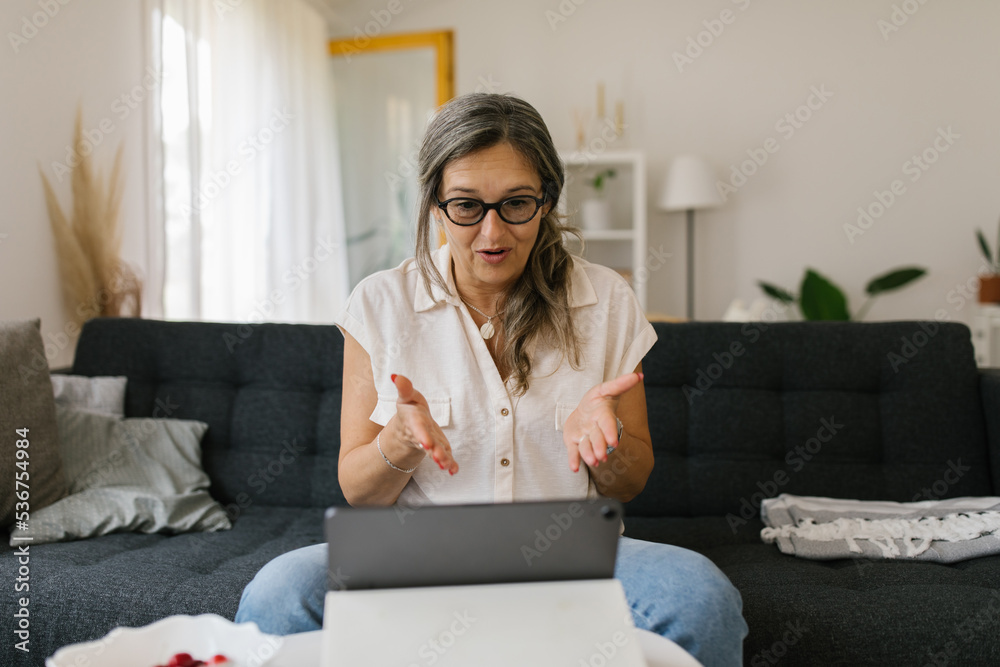 Adult woman having video call at home using tablet Adult woman having video call at home using tablet