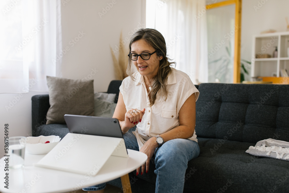 Adult woman having video call at home using tablet Adult woman having video call at home using tablet