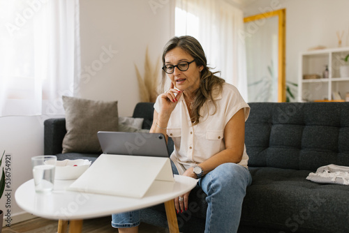 Adult woman having video call at home using tablet