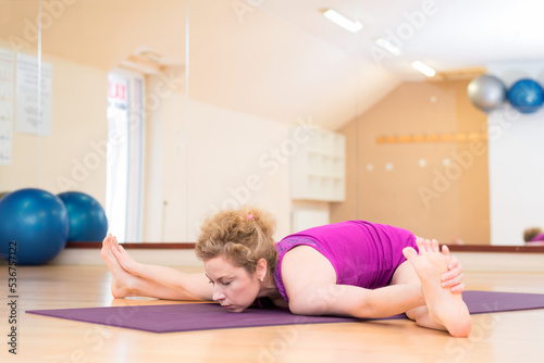 Young woman doing yoga exercise in the yoga studio