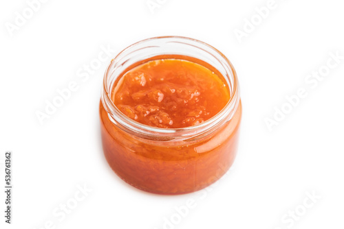 Carrot jam with cinnamon in glass jar isolated on white. Side view.