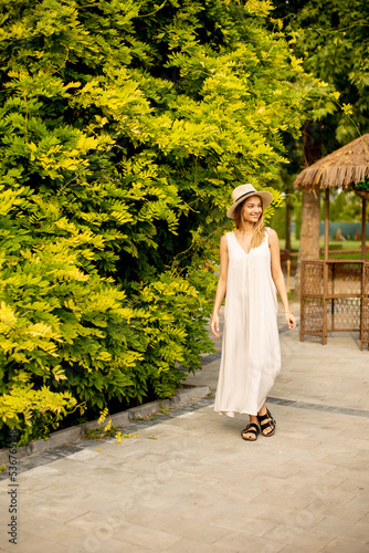 Young woman with hat walkin...