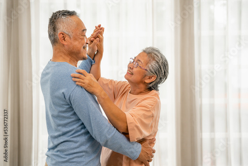 Asian couple senior dancing at home with happy expression and, Elderly man and woman with smiling faces convey satisfaction at the beautiful time, Retirement Lifestyle