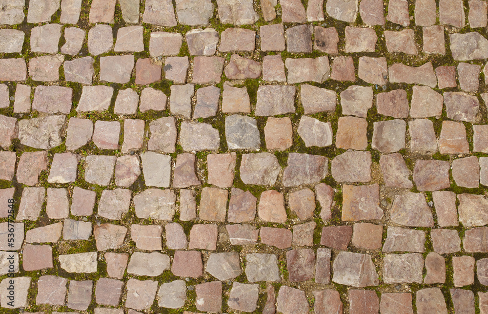 Granite cobblestoned pavement background. Full frame of regular square cobbles in rows. Natural stone textured background. 