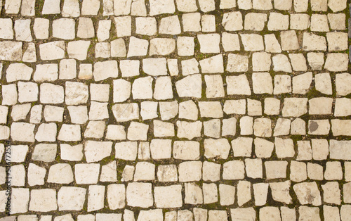 Granite cobblestoned pavement background. Full frame of regular square cobbles in rows. Natural stone textured background. 