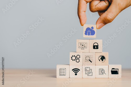  Cloud computing to download and loading data information and upload on system network application. Technology transformation. Hand holding wooden cube block icon.