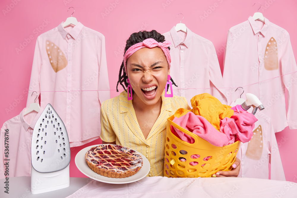 Displeased angry housewife frowns face feels annoyed does different