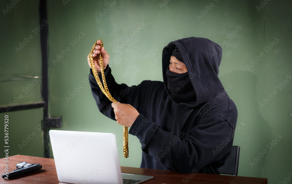 The thief wore a jacket, covered his head with a black veil, and looked at the stolen gold. The thief wore a jacket, covered his head with a black veil, and looked at the stolen gold.