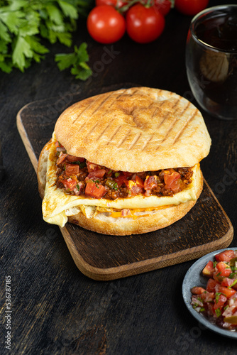 Israeli fast food sabich sandwich with vegetables, eggs on wooden background. vertical photo