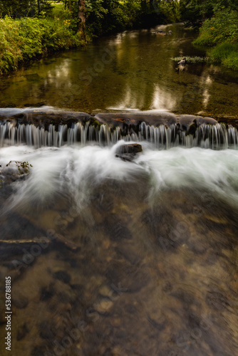 Small waterfall on small river in Golden Mountains at sunny day