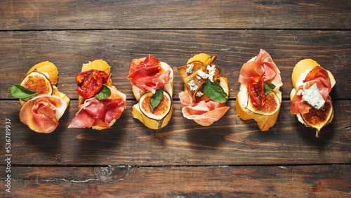 Appetizers board with traditional spanish tapas set. Italian antipasti bruschetta with prosciutto  cream cheese and fig