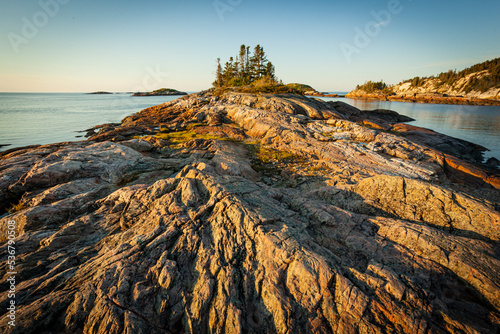 Dramatic sunrise over the rock formations of Ragueneau, a small town on the shore of the St. Lawrence River in Quebec, Canada photo