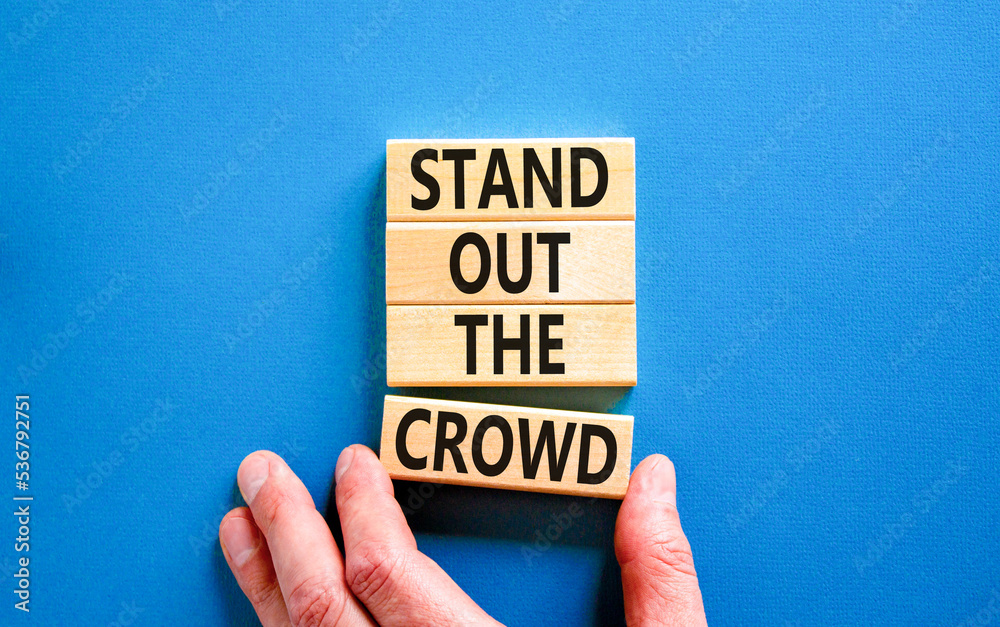 Stand out the crowd symbol. Concept words Stand out the crowd on wooden