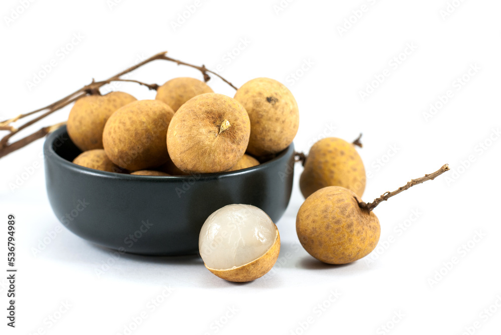 Sweet longan fruit in a black ceramic cup and placed on a white floor. Sweet longan fruit in a black ceramic cup and placed on a white floor.