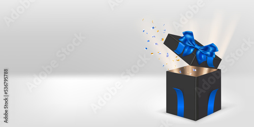 Festive illustration with open black gift box with blue ribbons and bow. Pieces of serpentine and rays of light fly out of it