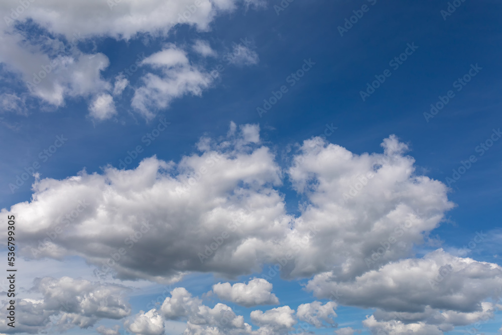The wind blows fluffy white clouds in the blue sky The wind blows fluffy white clouds in the blue sky