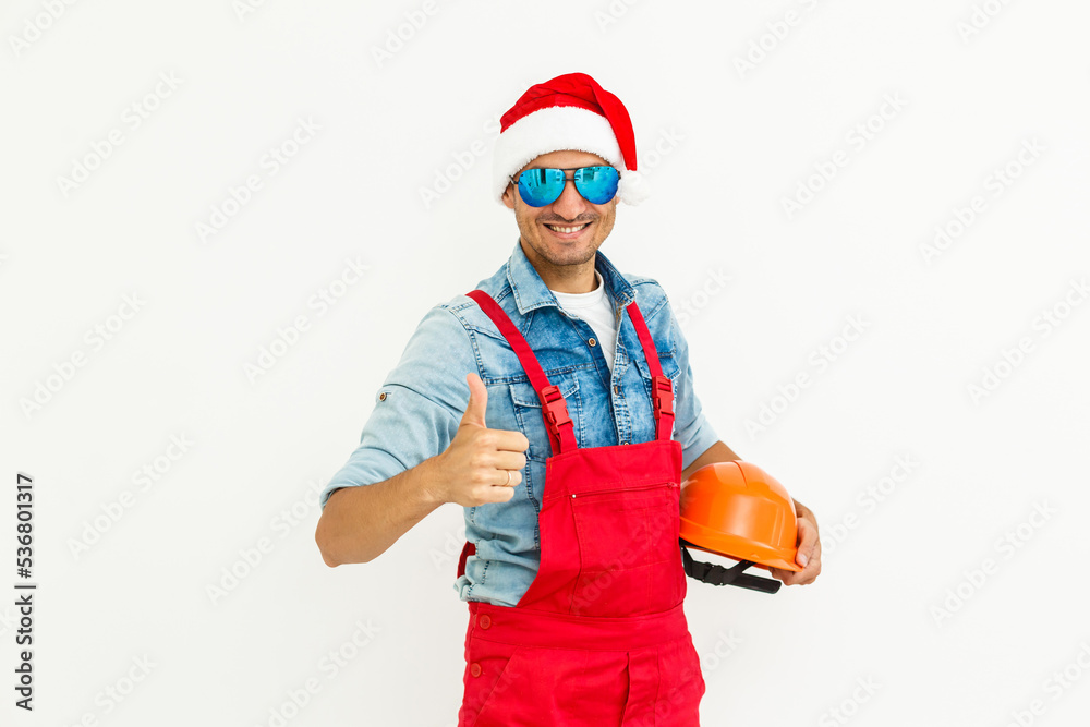 The guy, in uniform and Santa's hat, holds a drilland. Isolated on white background.