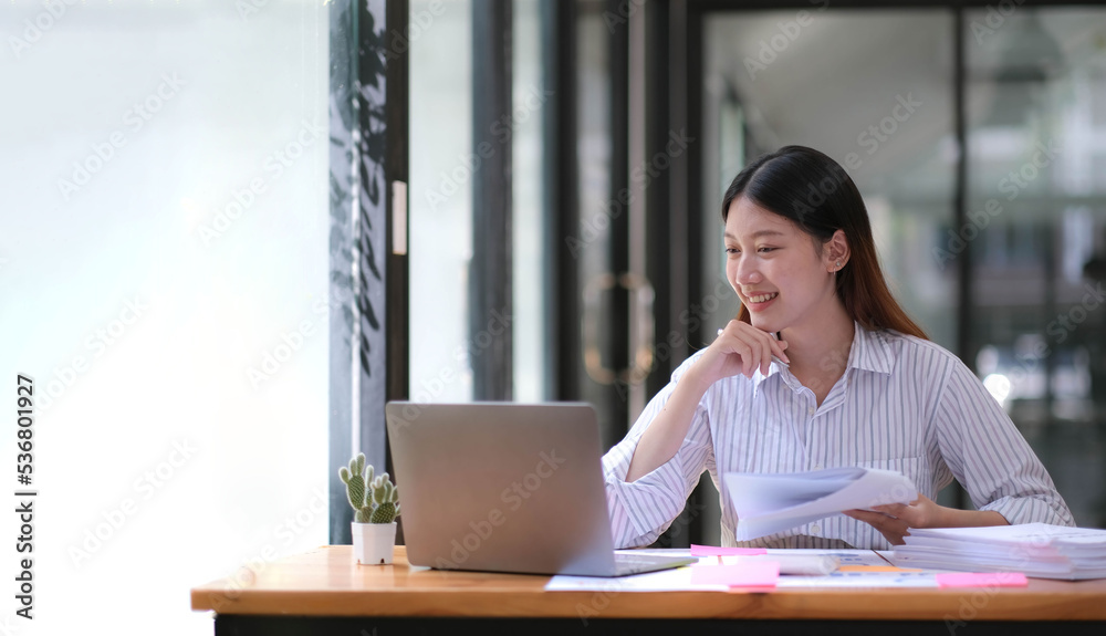 Asian young business women work from home new project modern loft,laptop in office.Analyze plans,papers, texting keyboard. Asian young business women work from home new project modern loft,laptop in office.Analyze plans,papers, texting keyboard.