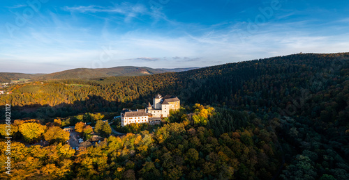 panorama of Lockenhaus Castle surrounded by autumn forest in warm evening light