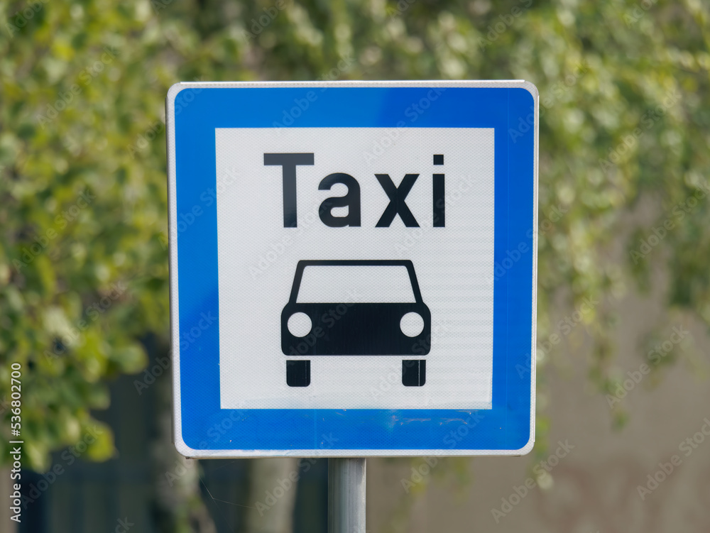 Close-up photo of a blue Taxi stand sign attached to a metal pole Close-up photo of a blue Taxi stand sign attached to a metal pole