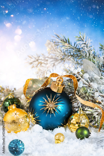 Christmas and New Year decor. Christmas balls and snowy fir branches in snow background. Winter holiday greeting card.
