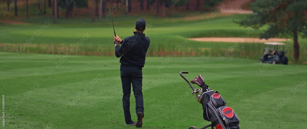 Caucasian man playing golf, striking a ball during the course Caucasian man playing golf, striking a ball during the course