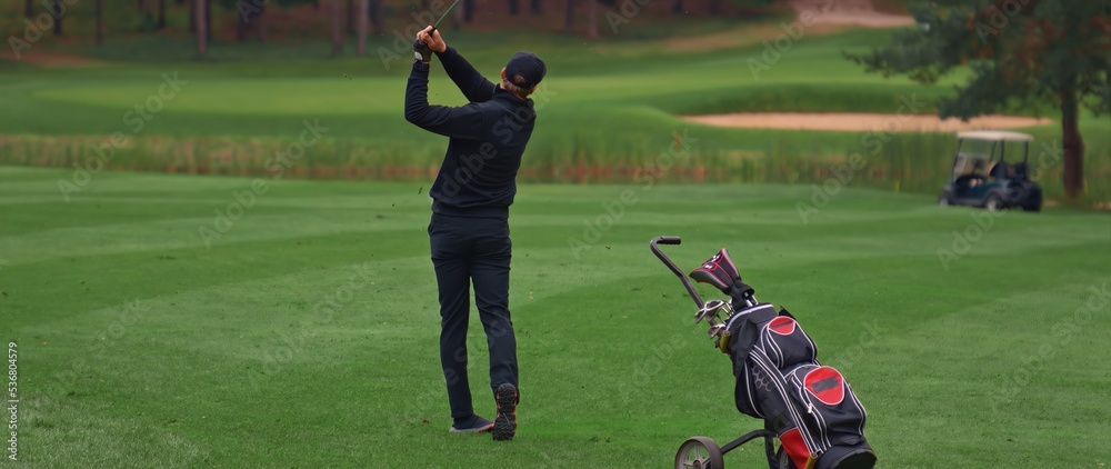 Caucasian man playing golf, striking a ball during the course Caucasian man playing golf, striking a ball during the course