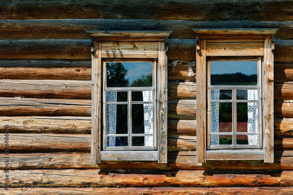 Two windows in a wooden log house
