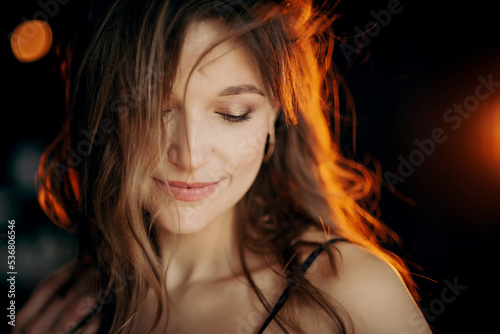 Beautiful  woman with natural long hair posing on dark background. Hair care, beauty conception. Copy, empty space for text