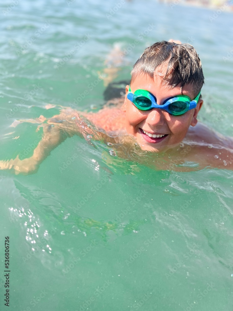 Caucasian boy wear scuba mask swim  in the sea close portrait with wide big smile