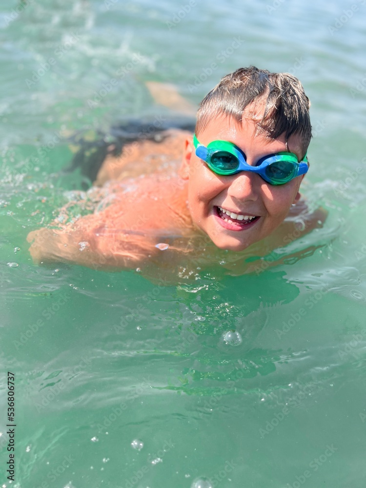 Naklejka premium Caucasian boy wear scuba mask swim in the sea close portrait with wide big smile