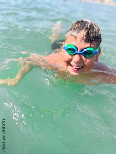 Caucasian boy wear scuba mask swim in the sea close portrait with wide big smile