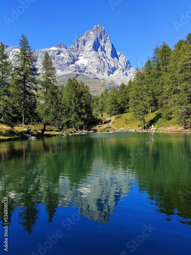il riflesso del monte cervino e del cielo sereno nel lago blu photo