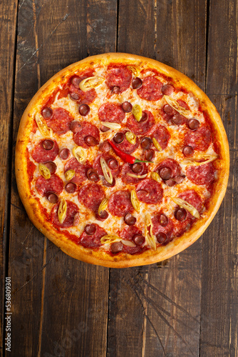 Pepperoni and sausage pizza. On a wooden table.