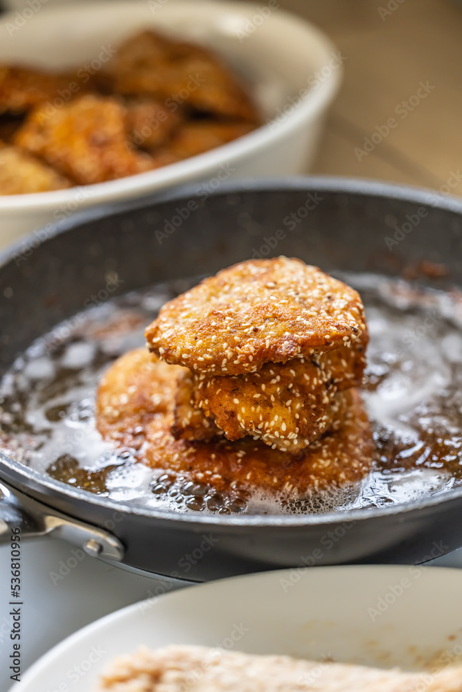 Schnitzels with sesame seeds in a frying pan Schnitzels with sesame seeds in a frying pan
